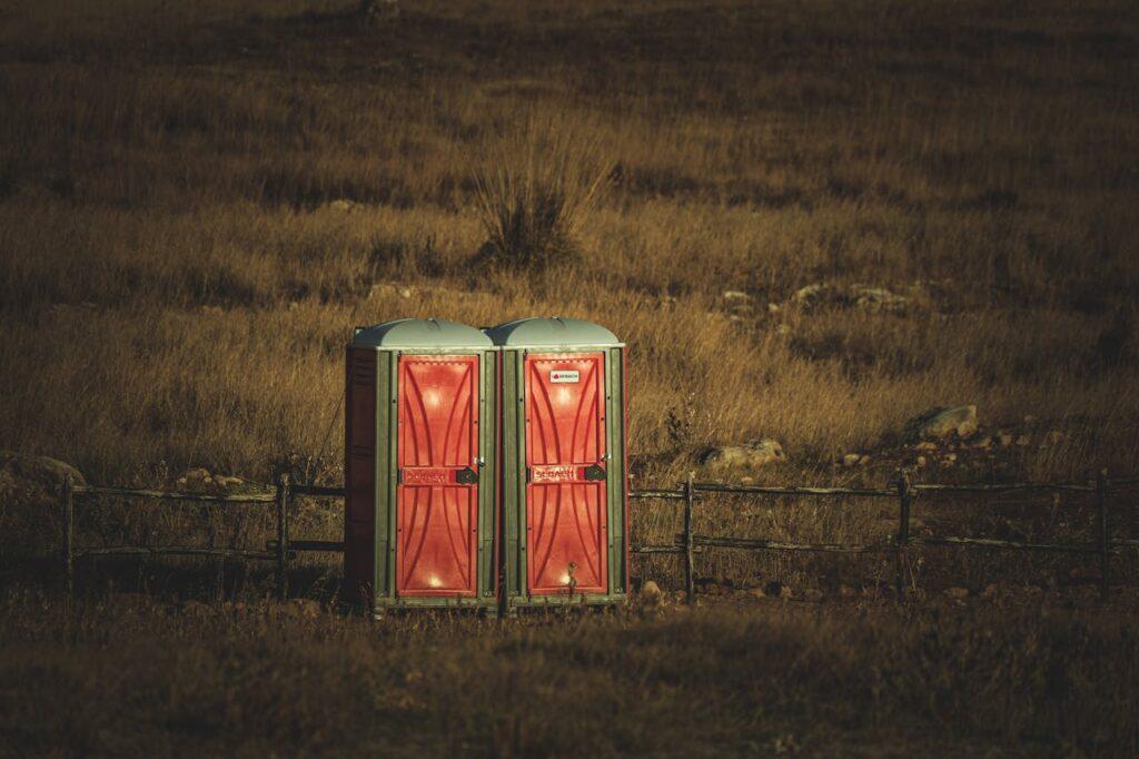 two portable toilets in a field